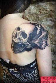 a woman's shoulder skull tattoo pattern