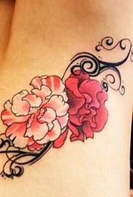 Sieviešu viduklis ir glīts ziedu tetovējums