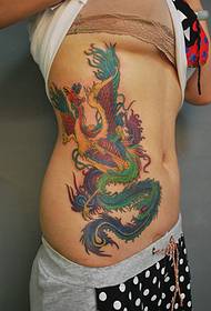 a beautiful phoenix tattoo on a woman's waist and abdomen