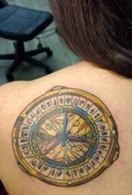 belle photo de tatouage de boussole en or sur le dos de la femme