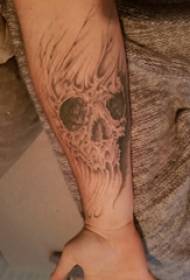 Taro tatuiruotės studento rankos ant pilkos kaukolės tatuiruotės nuotrauka