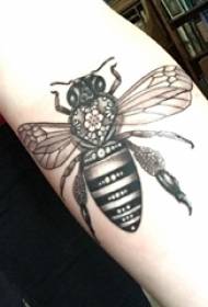 Cô gái hình xăm động vật nhỏ với hình xăm con ong đen trên cánh tay