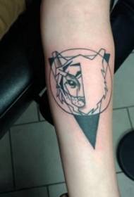 Braç de nena de tatuatges d'animals geomètrics sobre una imatge de tatuatge d'animal geomètric de color negre