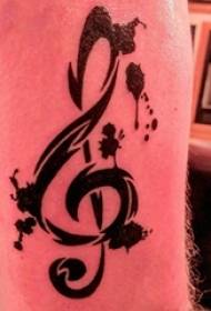 Bracciu di una ragazza tatuale di nota musicale nantu à una stampa di tatuà di nota nera