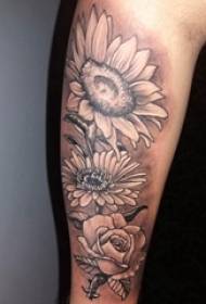 Saulėgrąžų tatuiruotės paveikslėlio berniuko ranka ant juodų gėlių tatuiruotės paveikslo