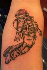 Materiál tetovania na ramene, tetovanie mužského astronauta na čiernom ramene