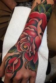 Der Arm des Rose-Tätowierungsmädchens auf farbigem Blumentätowierungsmuster