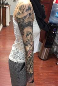 Tatuiruotės rankos mergaitės juodos pilkos spalvos personažo tatuiruotės nuotrauka ant mergaitės rankos