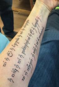 Szanszkrit tetoválás kifejezés Férfi hallgató karja a szanszkrit tetoválás képén