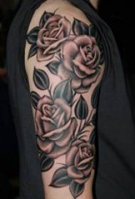 Ko te ringa o te tattoo tattoo a Rose e mau ake ana i te pikitia puawai puawai