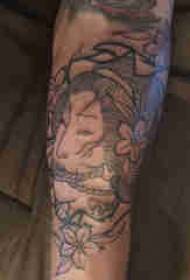 Portret personaj braț de băiat pe imagine de tatuaj floare și geisha
