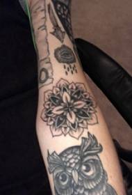 Erkek kolundaki siyah gri dövme tarzı siyah ve beyaz çiçek dövme resmi
