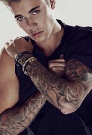 I-Justin Bieber tattoo yengalo yenkwenkwezi kwintyatyambo kunye nefoto yesilwanyana