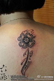 Beautiful and stylish four-leaf clover tattoo on the back of the beautiful woman