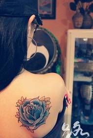 Woman back colored rose tattoo work