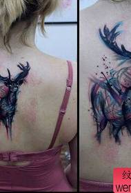 Woman's back splashing antelope tattoos by the tattoo show
