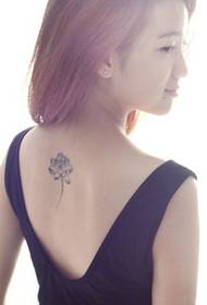 Una bella bellesa de moda a l'esquena del model de tatuatge de lotus en blanc i negre