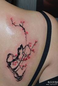Krásne dievčenské krásne slivkové tetovanie na chrbte