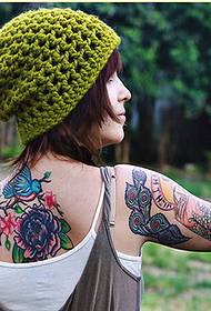 Slika modnega ženskega hrbta lepe cvetne tetovaže