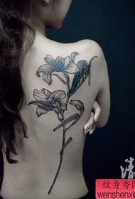 Красив и красив черно-бял модел татуировка на лилия на гърба на красавицата
