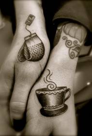 Mano gris taza de té con patrón de tatuaje de guantes