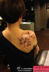 Ljepotica iza ramena prekrasnog uzorka tetovaže lotosa i leptira