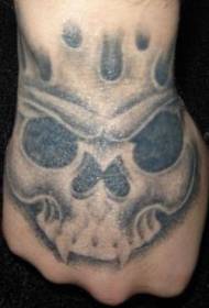 Patró de tatuatge de crani negre per als ulls grossos a la part posterior de la mà