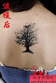 Djevojka s prekrasnim tetovažom drveta i ptica na leđima