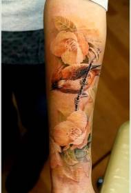 Arm realistically painted bird with floral tattoo pattern