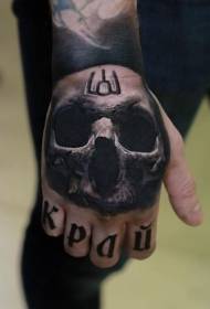 Hand back realistic human skull with letter tattoo pattern