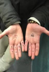 17 petits tatuatges dibuixats a mà al dors de la mà i el palmell