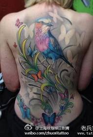 Gadis dengan tato burung yang cantik di bagian belakang