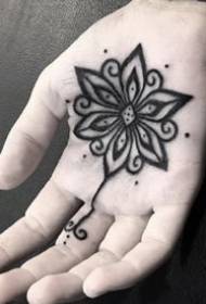 Creative black small tattoo pattern in the palm of the hand
