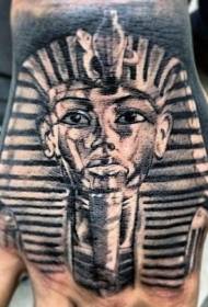 Realistic black and white pharaoh statue tattoo on the back of the hand