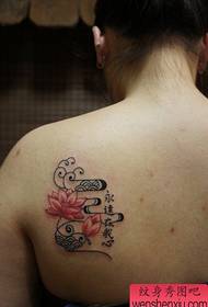 Мала свежа жена што работи на тетоважа со лотос во грбот