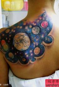 Patrón de tatuaje estrellado de color fresco en la espalda femenina