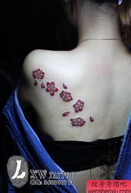 Schöne und schöne Kirschblütentätowierung auf der Rückseite der schönen Frau