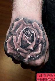 En populær klassisk svart og hvit rosetatovering på baksiden av hånden