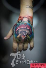 un tatouage de champignon à longue queue sur le dos de la main