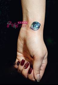Radošs plaukstas locītavas planētas tetovējuma attēls