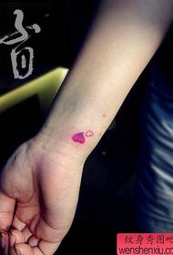 Meitenes plaukstas locītavas mazā mīlas tetovējuma raksts