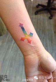 Woman wrist colored cross tattoo work