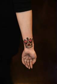 Fotografi e vogël e tatuazheve të krahut të freskët të kurorës