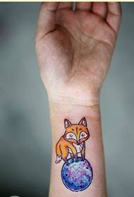 Pergelangan tangan wanita cantik tampak berwarna-warni gambar tato rubah berbintang