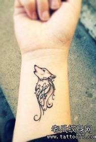 a woman's wrist wolf tattoo pattern