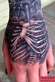 uma tatuagem de esqueleto personalizada na parte de trás da mão