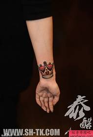 Mano da muller pequeno patrón de tatuaxe de coroa colorida fresca