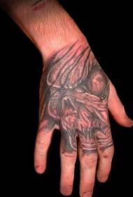 Na zadnji strani roke je osupljiv vzorec tatoo obraz pošasti pošast obraz
