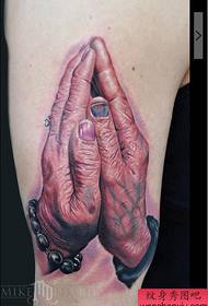 Vecs vīrietis lūdzas roku tetovējuma attēlu uz lielās rokas