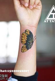 Imagen femenina del tatuaje de la mariposa del color de la muñeca
